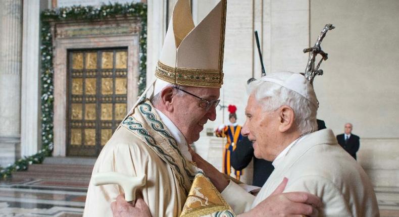 Pope Francis (left) greets Pope emeritus Benedict XVI before the opening of the Holy Door to mark the start of the Jubilee Year of Mercy at the Vatican, on December 8, 2015