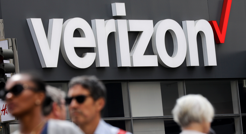 FILE- In this May 2, 2017, file photo, people walk past a Verizon store in Manhattan's midtown area, in New York. Verizon Communications Inc. reports financial earns on Friday, Oct. 25, 2019. (AP Photo/Bebeto Matthews, File)