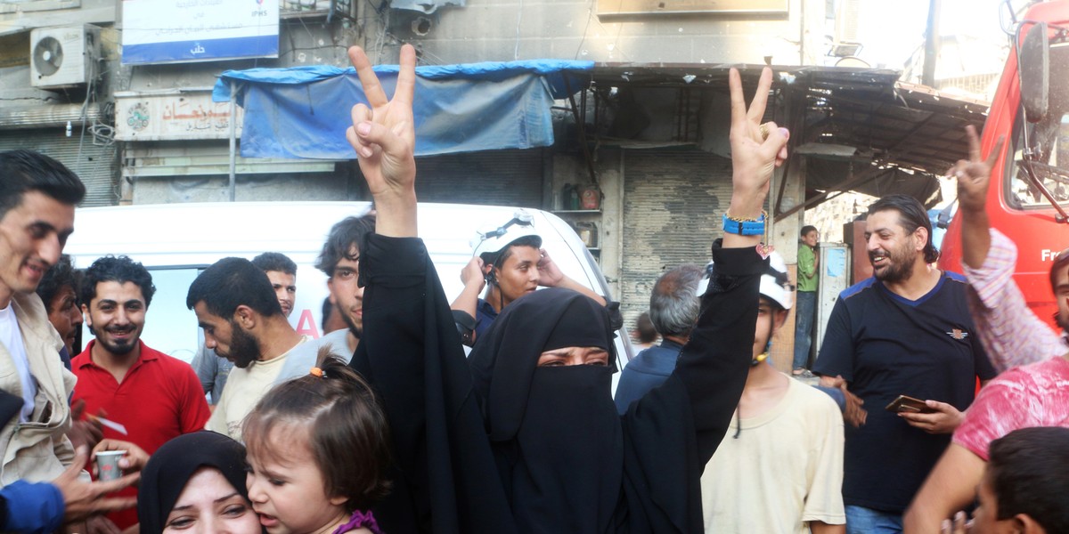 A woman flashing the victory sign Saturday after hearing of the breaking of the siege of rebel-held areas of Aleppo, Syria.