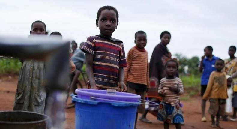 Children watch as women pump water from a borehole near Malawi's capital Lilongwe, February 2, 2016. REUTERS/Mike Hutchings