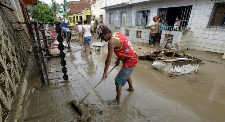 Residents of the city of Barreiros clean their houses affectd by floods, due to heavy rains in Pernambuco state, northeastern Brazil, on May 30, 2017