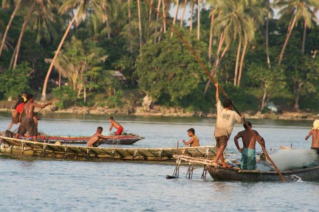 Tubylcy na swoich łódkach z wydrążonych pni drzew