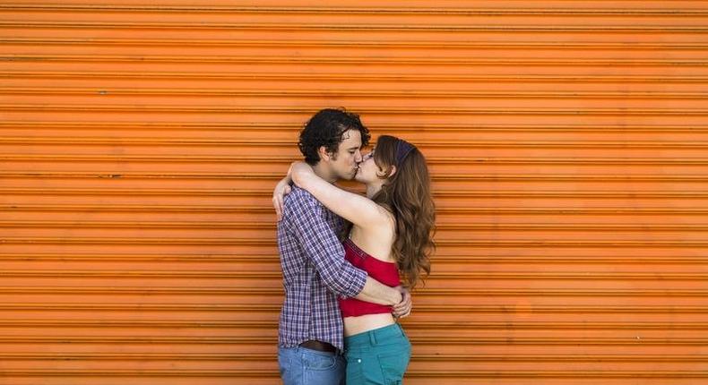 ___8918187___2018___9___29___20___romantic-couple-kissing-in-front-of-orange-shutter-royalty-free-image-501884093-1537805601