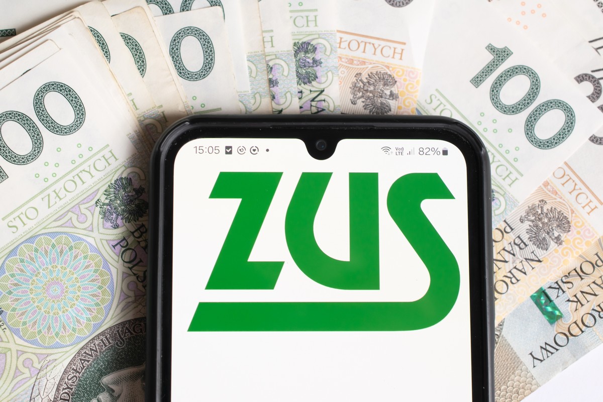 logo zus na smartfonie na tle banknotów