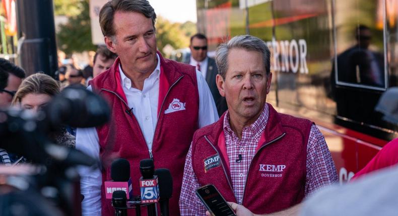 Georgia Gov. Brian Kemp, right, campaigns for his reelection bid alongside Virginia Gov. Glenn Youngkin, in Alpharetta, Ga., on September 27, 2022.