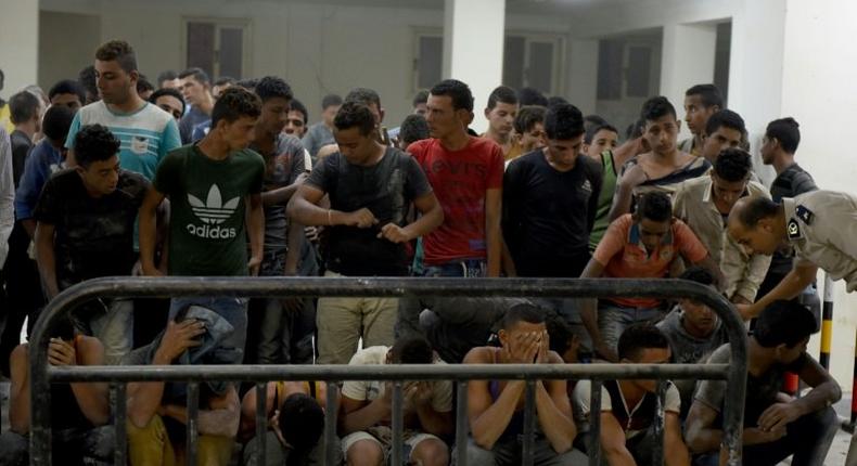 Survivors from a boat that capsized, off Egypt's north coast are seen in a police station in Rashid in northern Egypt on September 22, 2016 A boat carrying up to 450 migrants capsized in the Mediterranean off Egypt's north coast, drowning 42 people and prompting a search operation that rescued 163 passengers, officials said. The vessel overturned off the port city of Rosetta, police and health officials said.