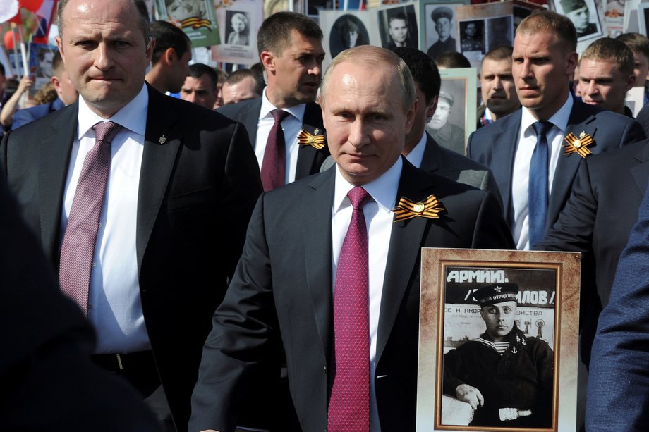 Russian President Vladimir Putin holds the portrait of his father, war veteran Vladimir Spiridonovich Putin, as he takes part in the Immortal Regiment march during Victory Day celebrations.