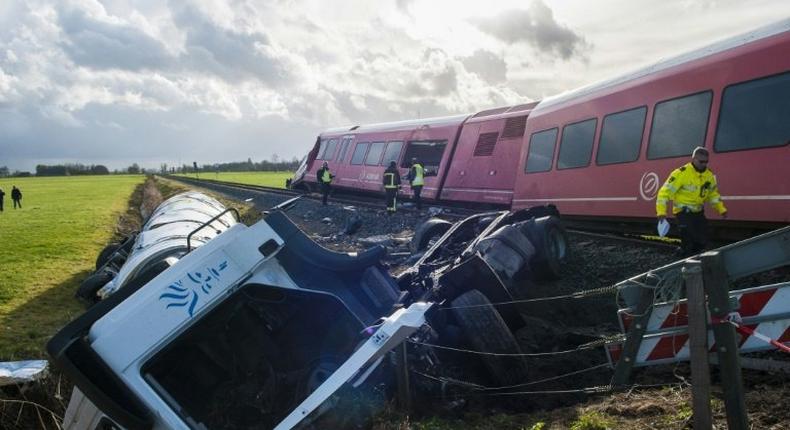 A policeman walks past the wreckage of a derailed passenger train and a smashed milk tanker after a crash near Winsum, northeast Netherlands on November 18, 2016