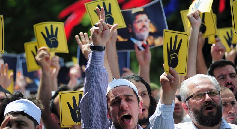 Pro-Islamist demonstrators shout slogans in favour of former Egyptian President Mohamed Mursi and hold signs that show the Rabaa hand gesture, which symbolizes support for the Muslim Brotherhood, during a rally in front of the Haghia Sophia museum at Sultanahmet square in Istanbul, Turkey, May 24, 2015. REUTERS/Yagiz Karahan