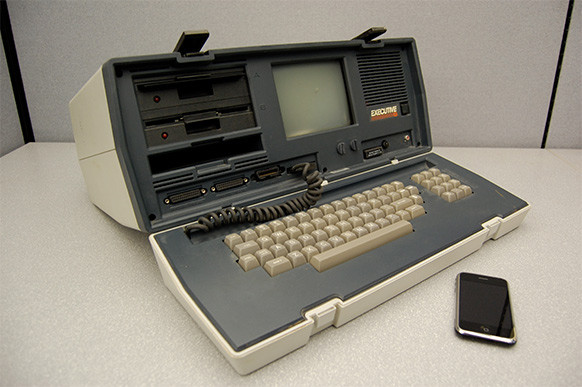Komputer Osborne Executive z 1982 roku z procesorem Zilog Z80, taktowanym z częstotliwością 4 MHz. Obok iPhone z 2009 roku z procesorem Cortex A8 o ponad 2500 razy większej mocy obliczeniowej 