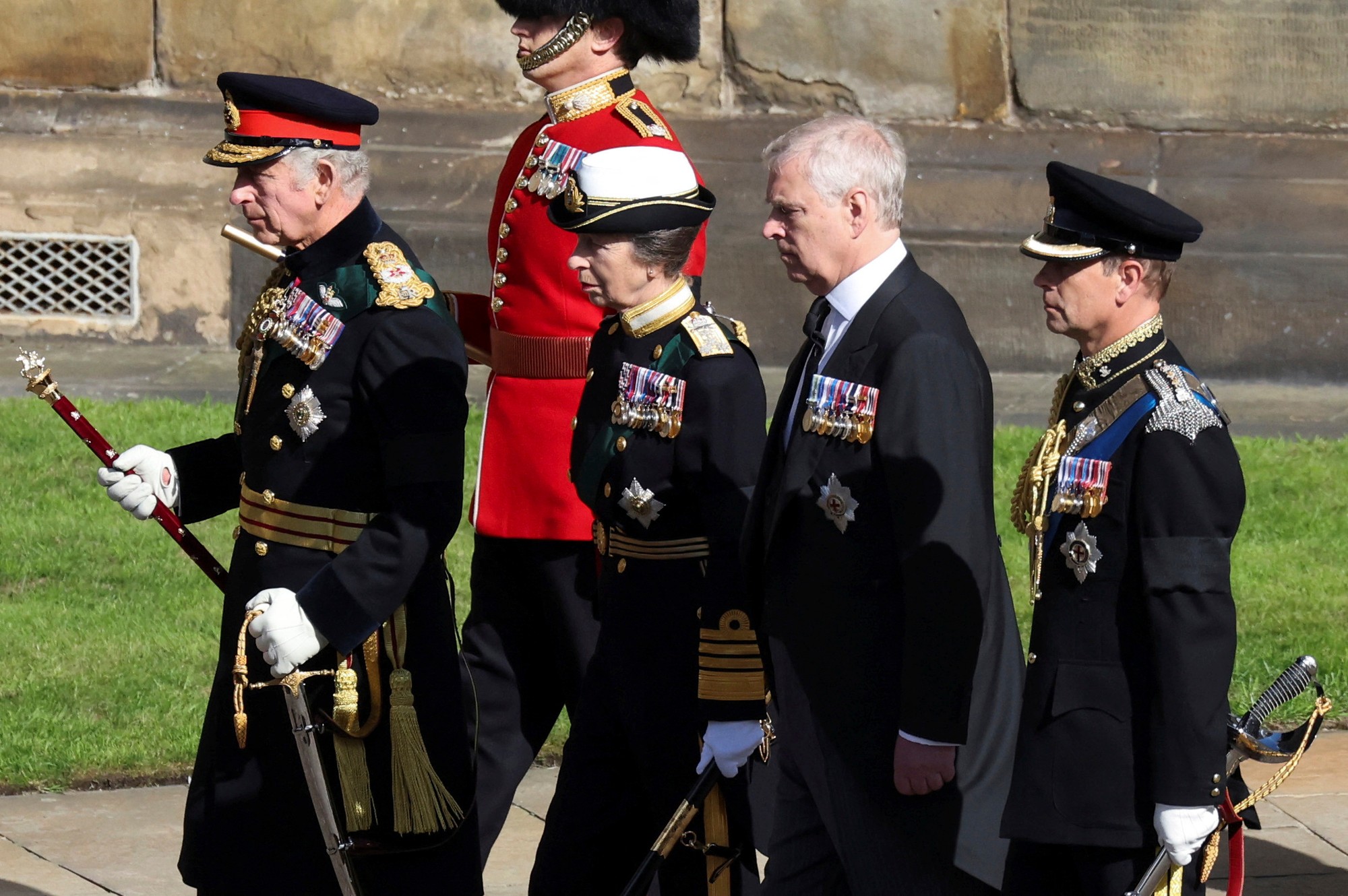 Na snímke zľava britský kráľ Karol III. (vľavo) a jeho súrodenci - princezná Anna a princovia Andrew a Edward kráčajú za pohrebným vozom, ktorý preváža rakvu s pozostatkami ich matky - britskej kráľovnej Alžbety II.