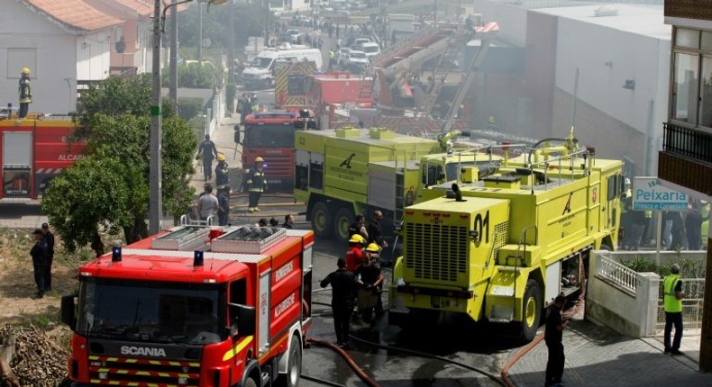 Rescue crews work after a plane crashed into a supermarket warehouse in Tires, near Sintra on April 17, 2017