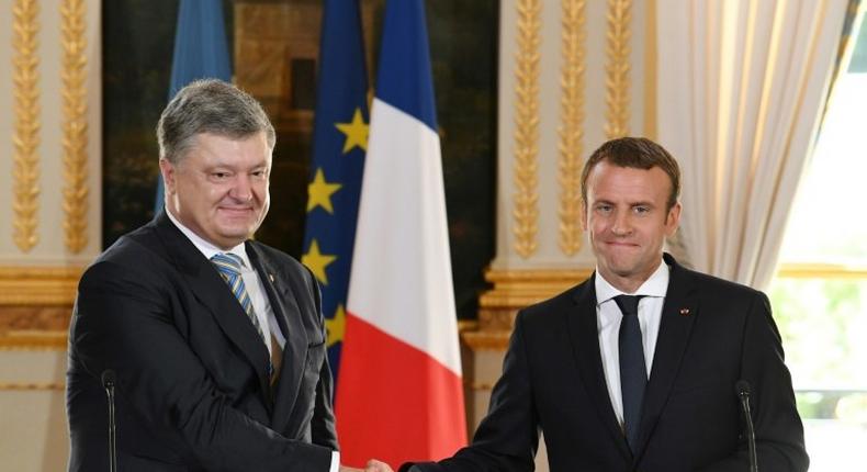 French President Emmanuel Macron (R) shakes hands with his Ukrainian counterpart Petro Poroshenko during a joint press conference after a meeting at the Elysee Palace in Paris on June 26, 2017