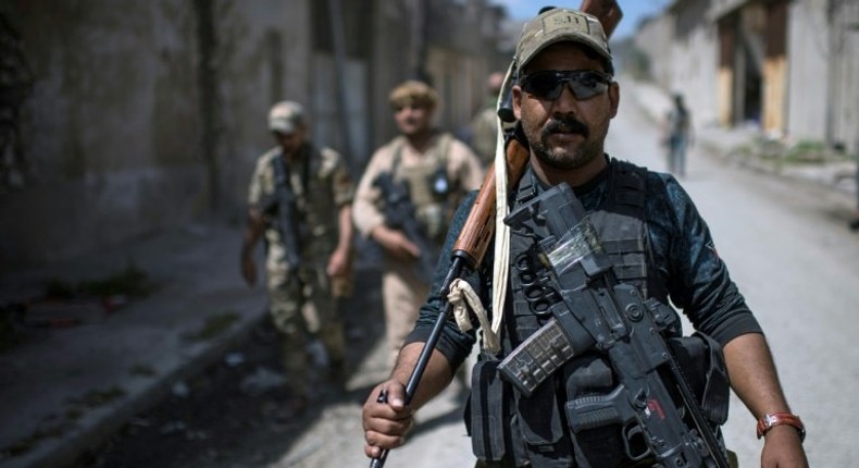 A member of Iraq's elite Rapid Response Division walks down a street during their advance in western Mosul on April 19, 2017