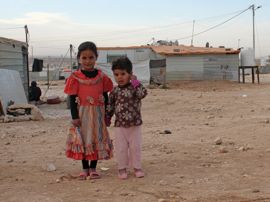 Syrian refugee children stand in front of their family caravan in Al Zaatari refugee camp in Jordan near the border with Syria, December 3, 2016.