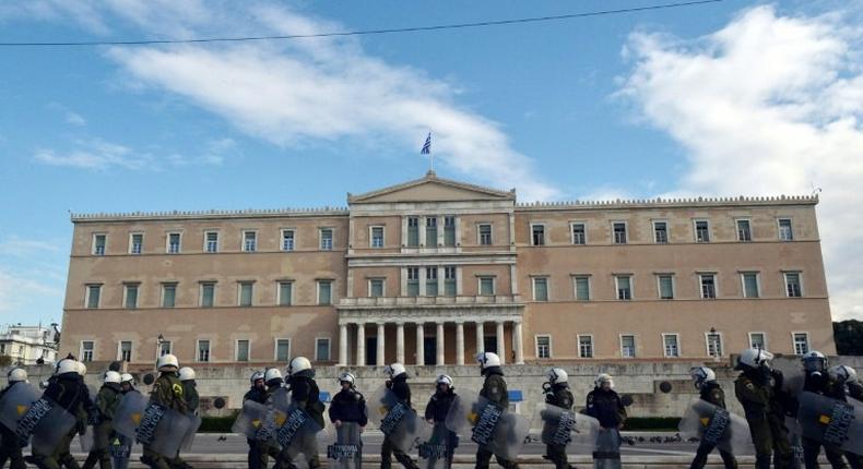 Greek police stand guard outside the parliament building in Athens during a protest on December 6, 2016