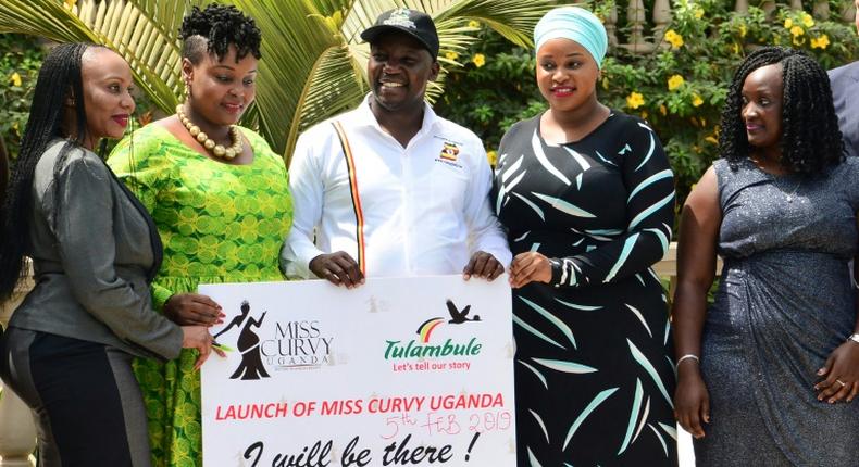 Uganda's Tourism Minister Godfrey Kiwanda posed with women during the launch of the Miss Curvy beauty contest in the capital Kampala