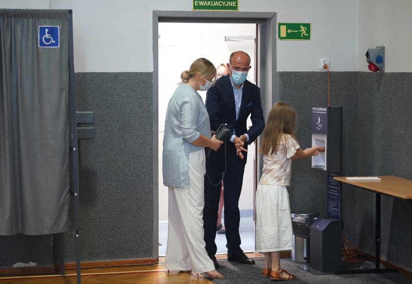 Borys Budka z rodziną. Przed wejściem do lokalu dezynfekują ręce