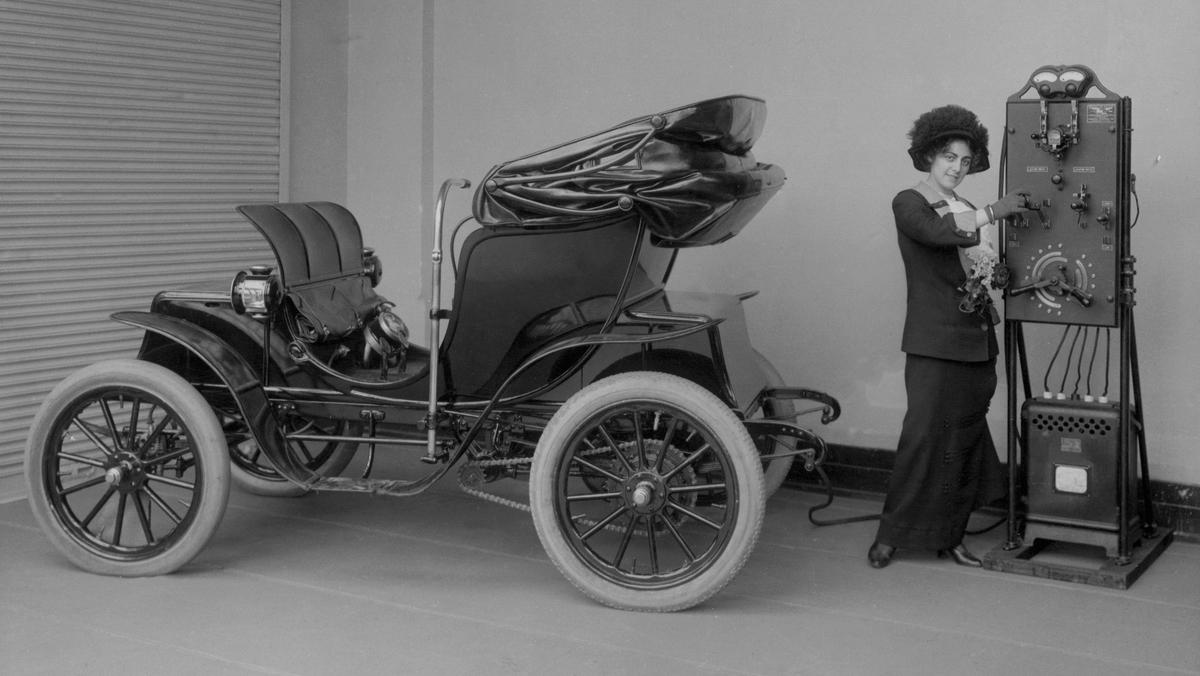 Elektryczny samochód Columbia Mark 68 Victoria ładowany przy użyciu ręcznej ładowarki. Firma Pope Manufacturing Company z Hartford w stanie Connecticut wyprodukowała samochód w 1906 r., a ładowarkę w 1912 r.