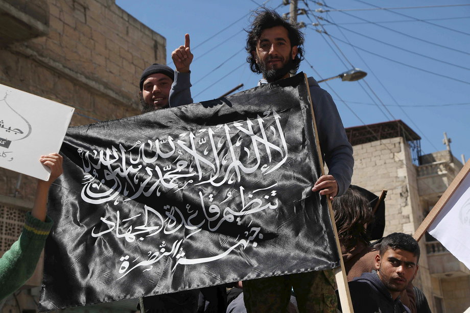 Residents hold a Nusra Front flag during a demonstration calling for the implementation of the Islamic Sharia law, in Al-Sakhour neighborhood of Aleppo, Syria April 24, 2015.