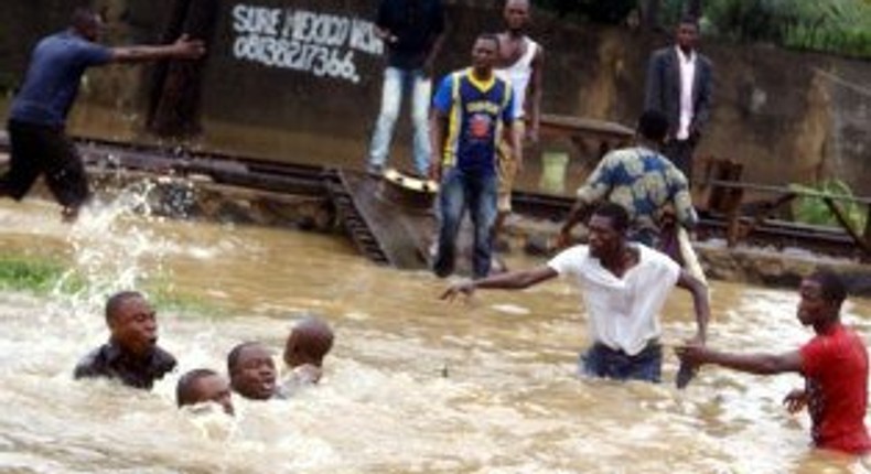 Some men are seen trying to navigate the flood.