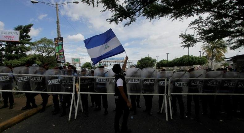 An activist waves a national flag during a march against the construction of the Interoceanic Grand Canal and denouncing what they claim to be electoral fraud in the November 6 elections Nicaragua, in Managua on December 1, 2016