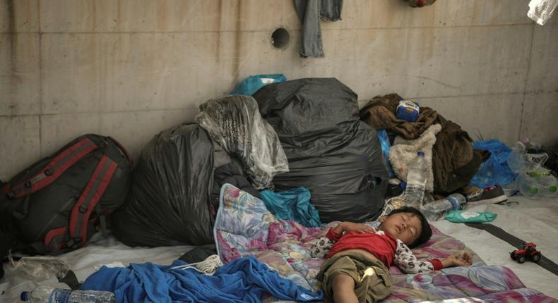 A child sleeps rough, exposed to the elements