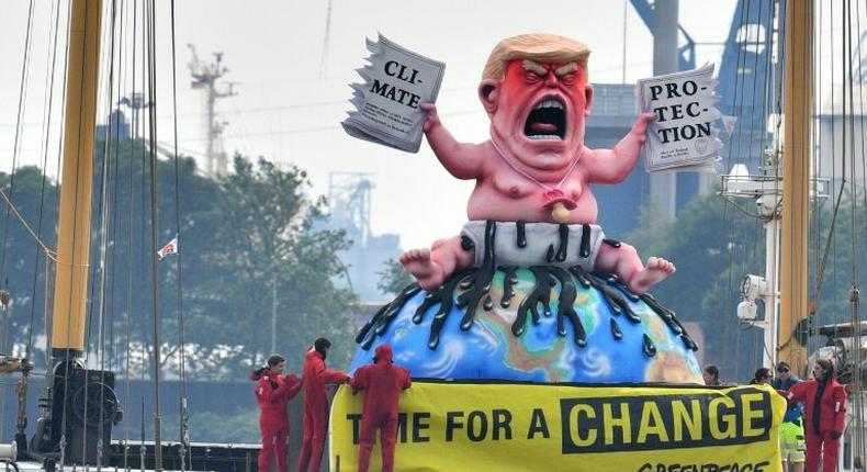 Greenpeace activists protest on a boat with a giant figure featuring US President Donald Trump in Hamburg, northern Germany where leaders of the world's top economies gather for a G20 summit