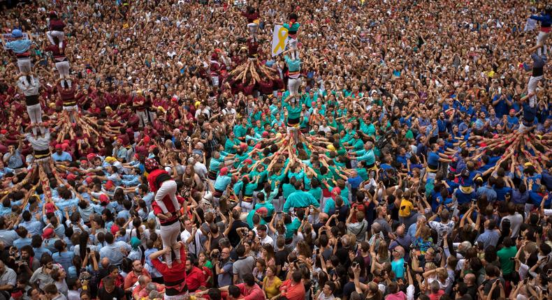 Participants make human towers or Castellers during the Saint Merce celebrations in San Jaime square in Barcelona, Spain.