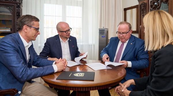 Wiceprezydent Jakub Mazur (z lewej) i starosta Włodzimierz Chlebosz (drugi z prawej) podpisują stosowne dokumenty.