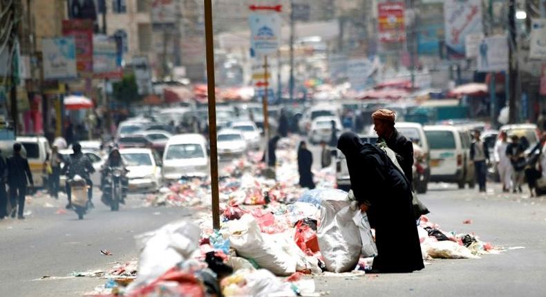 Yemenis salvage for discarded items in piles of rubbish lining a road in Sanaa on May 9, 2017