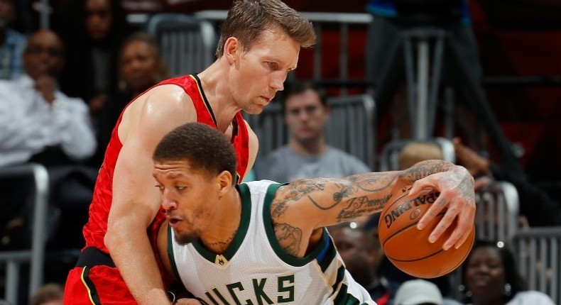 Michael Beasley (R) of the Milwaukee Bucks drives against Mike Dunleavy of the Atlanta Hawks during their NBA game at Philips Arena in Atlanta, Georgia, on January 15, 2017