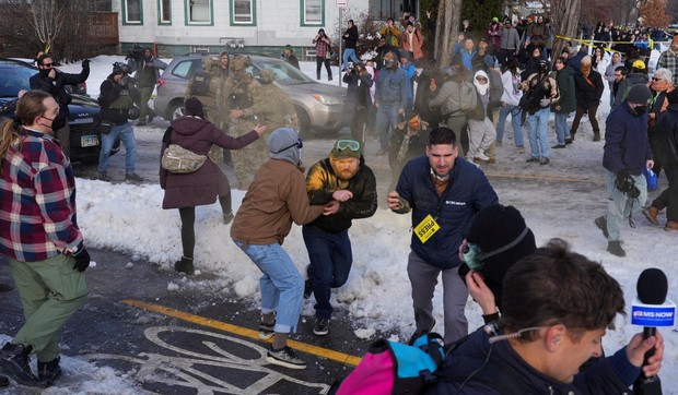 Pripadnici snaga bezbednosti rasteruju okupljenena mestu gde je američki imigracioni agent upucao ženu u vozilu | Foto: REUTERS/Tim Evans