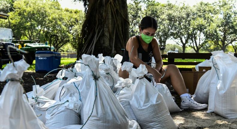 A woman prepares sand bags for the residents of Palmetto Bay near Miami as Florida prepares for the impact of Isaias