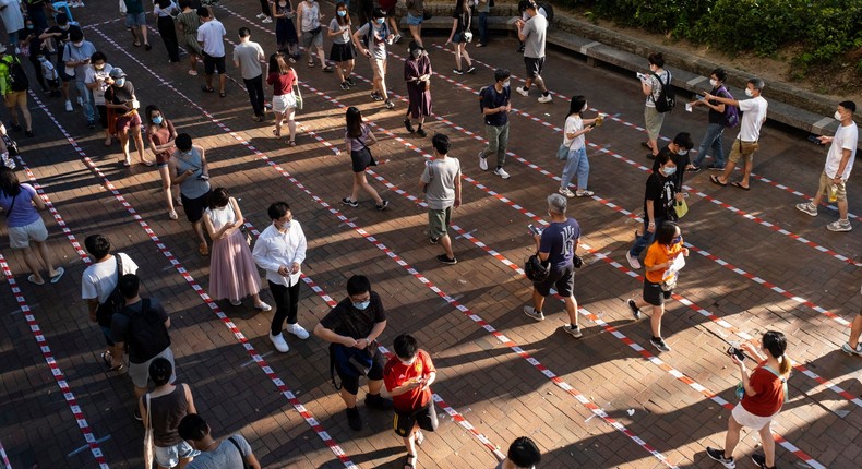 People observe social distancing as they queue up at a temporary polling station to vote for pro-democracy candidates during an unofficial primary elections. (Photo by Chan Long Hei/SOPA Images/LightRocket via Getty Images)