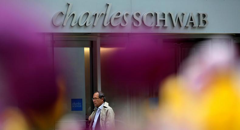 A man walks past a Charles Schwab investment branch in Chicago.