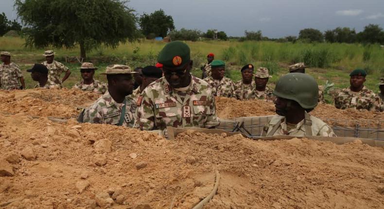 Chief of Army Staff, Lt.-Gen. Tukur Buratai (L), giving instructions to one of the soldiers in trench in frontline in Borno North