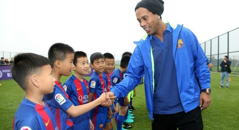 Brazilian player Ronaldinho meets children at the launch of a Barcelona football academy on the southern Chinese island of Hainan, on February 24, 2017