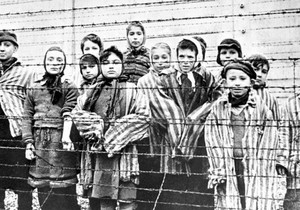 Grupa preživele dece iza ograde od bodljikave žice u nacističkom koncentracionom logoru u Aušvicu | Foto: Getty Images