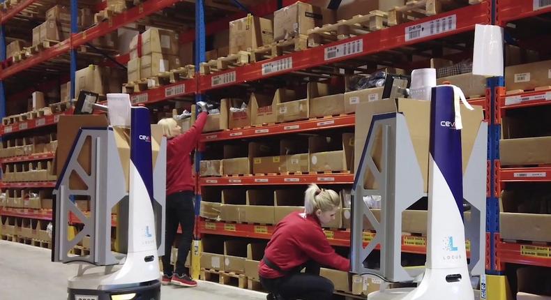 Locus robots work alongside workers in a Ceva Logistics warehouse.Locus Robotics