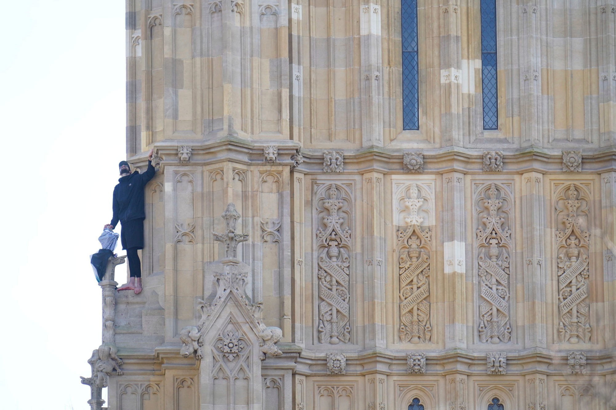 Na snímke muž s palestínskou vlakou, ktorý sa vyšplhal na Big Ben (oficiálne Alžbetina veža) Westminsterského paláca v Londýne v sobotu 8. marca 2025.
