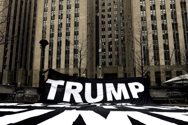 Demonstranci wystawiają baner przed sądem karnym w Nowym Jorku przed potencjalnym aktem oskarżenia Donalda Trumpa