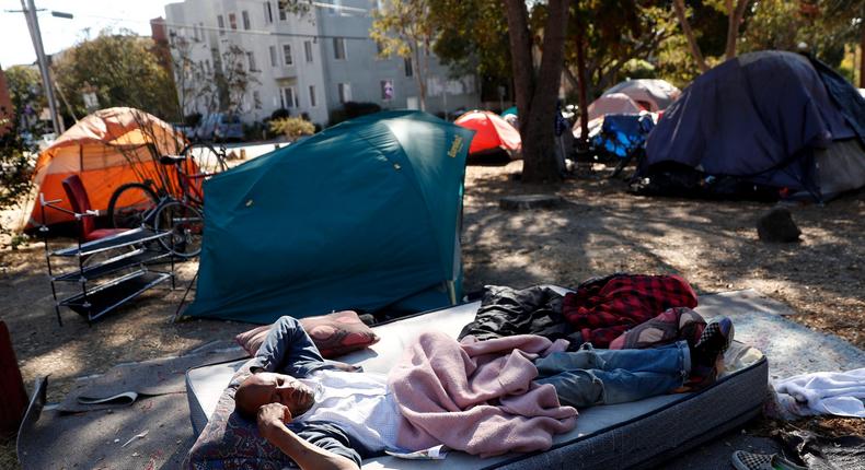 A man lays on a mattress in People's Park in Berkeley, California, on Tuesday, September 28, 2021.
