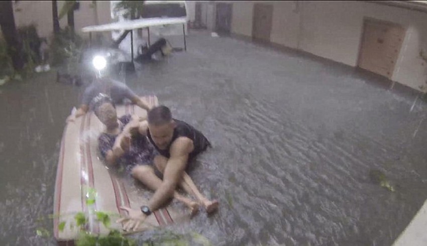 Ne plašeći se oborenih kablova, spsioci gaze kroz vodu do struka