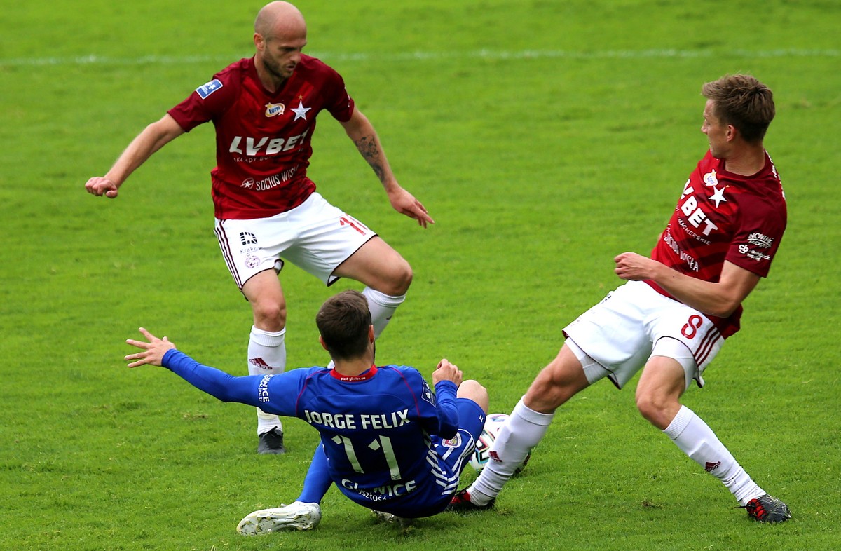 Piłkarz Piasta Gliwice Jorge Felix (C) oraz Vullnet Basha (L) i Łukasz Burliga (P) z Wisły Kraków podczas meczu piłkarskiej Ekstraklasy