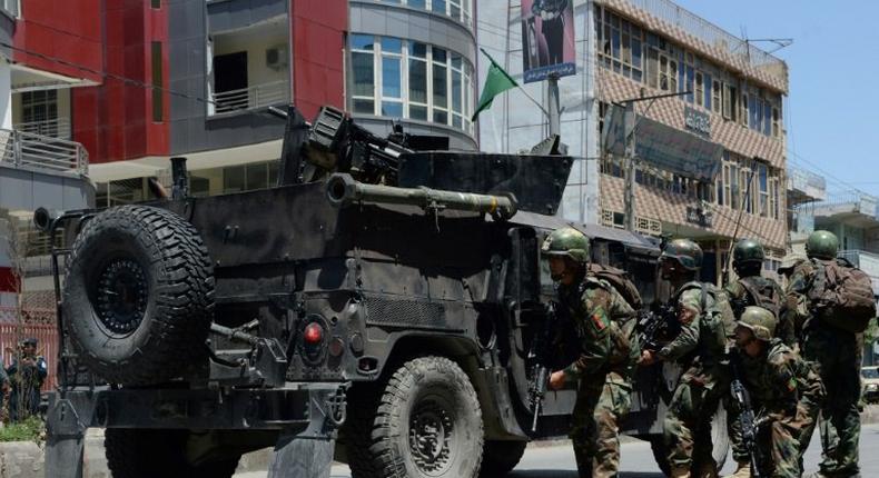 Afghan security forces take up a position at the site of suicide bombing in Jalalabad on May 17, 2017