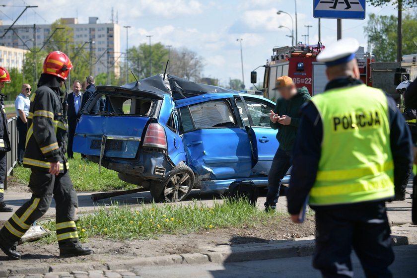 Samochód zaklinowany pomiędzy tramwajem a słupem. W środku ciężarna kobieta i dziecko