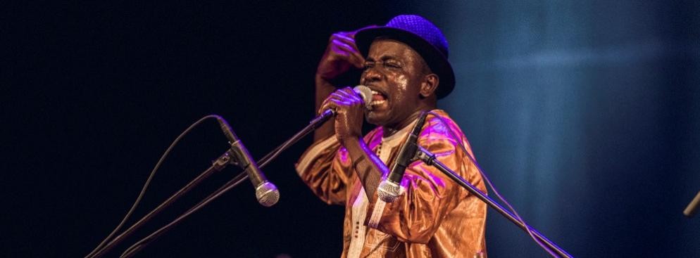 <strong>Balla Kouyaté</strong>
<br></br>
Ten koncert od początku był eksplozją rytmu. Balafon harmonijnie wybrzmiewał  w rockowych aranżacjach, a nawet w rytmach reggae. Balla Kouyaté przypominał jednak publiczności, że w tle jego muzyki obecne są tradycyjne opowieści. Jeden z utworów miał szczególne znaczenie – sławił Sundiatę Keitę, twórcę średniowiecznego Imperium Mali. To na jego dworze działał pierwszy griot i przodek artysty, po którym Balla Kouyaté otrzymał imię. Mimo współczesnych aranżacji nadal czuje się strażnikiem 700-letniej tradycji.
<br></br>
fot. Mateusz Bral
<br></br>