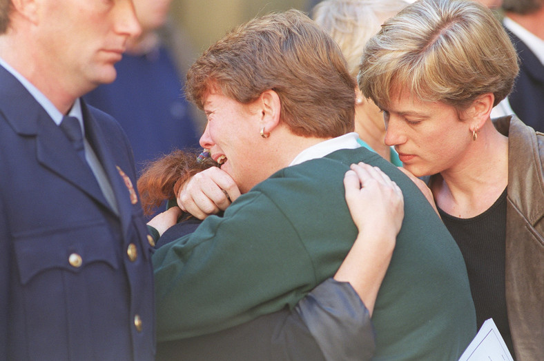 Żałobnicy pocieszają się nawzajem podczas nabożeństwa za 35 ofiarami Martina Bryanta, 1996 r.