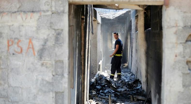 A firefighter walks in a burnt-out house in the village of Zrnovnica, near the Adriatic coastal town of Split in July 2017